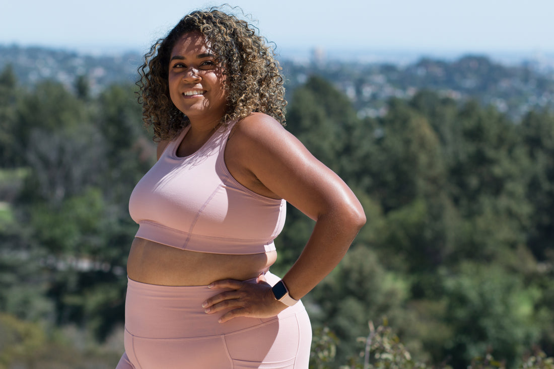 Plus size model wearing Superfit Hero's Sports Bra and Bike Shorts in color Blush.
