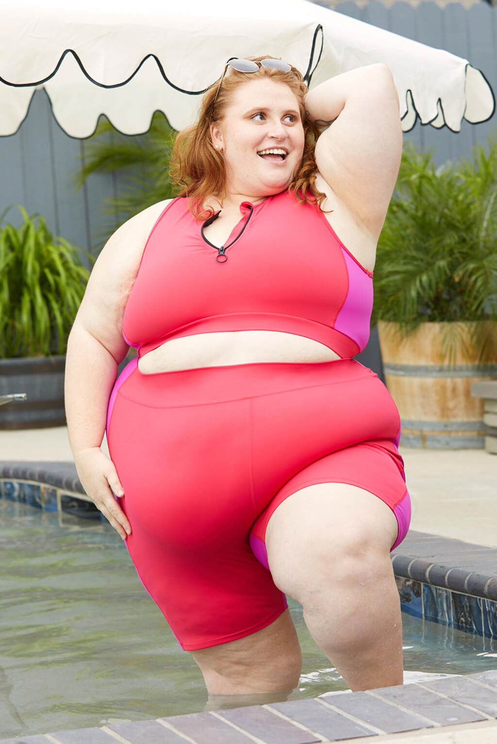 Plus size model wearing Superfit Hero's 9 Inch Swim Shorts in Colorblock Fuchsia.